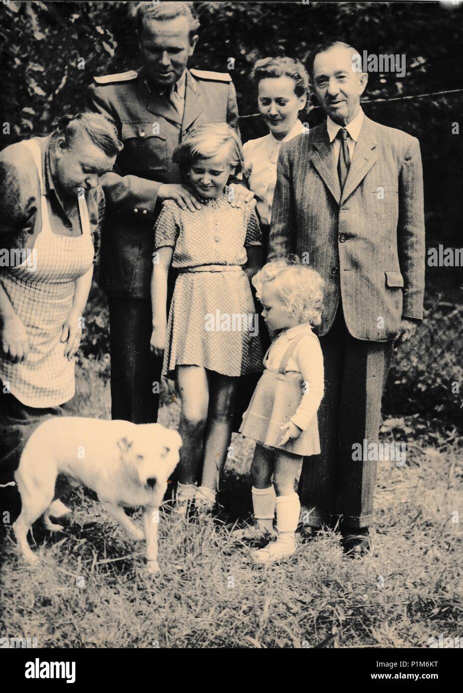 THE CZECHOSLOVAK SOCIALIST REPUBLIC - CIRCA 1960s: Retro photo shows family and dog outside. Black & white vintage photography Stock Photo