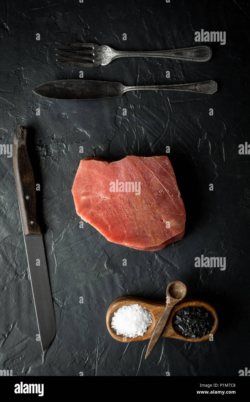 Raw Tuna Steak on Dark Stone Background Stock Photo