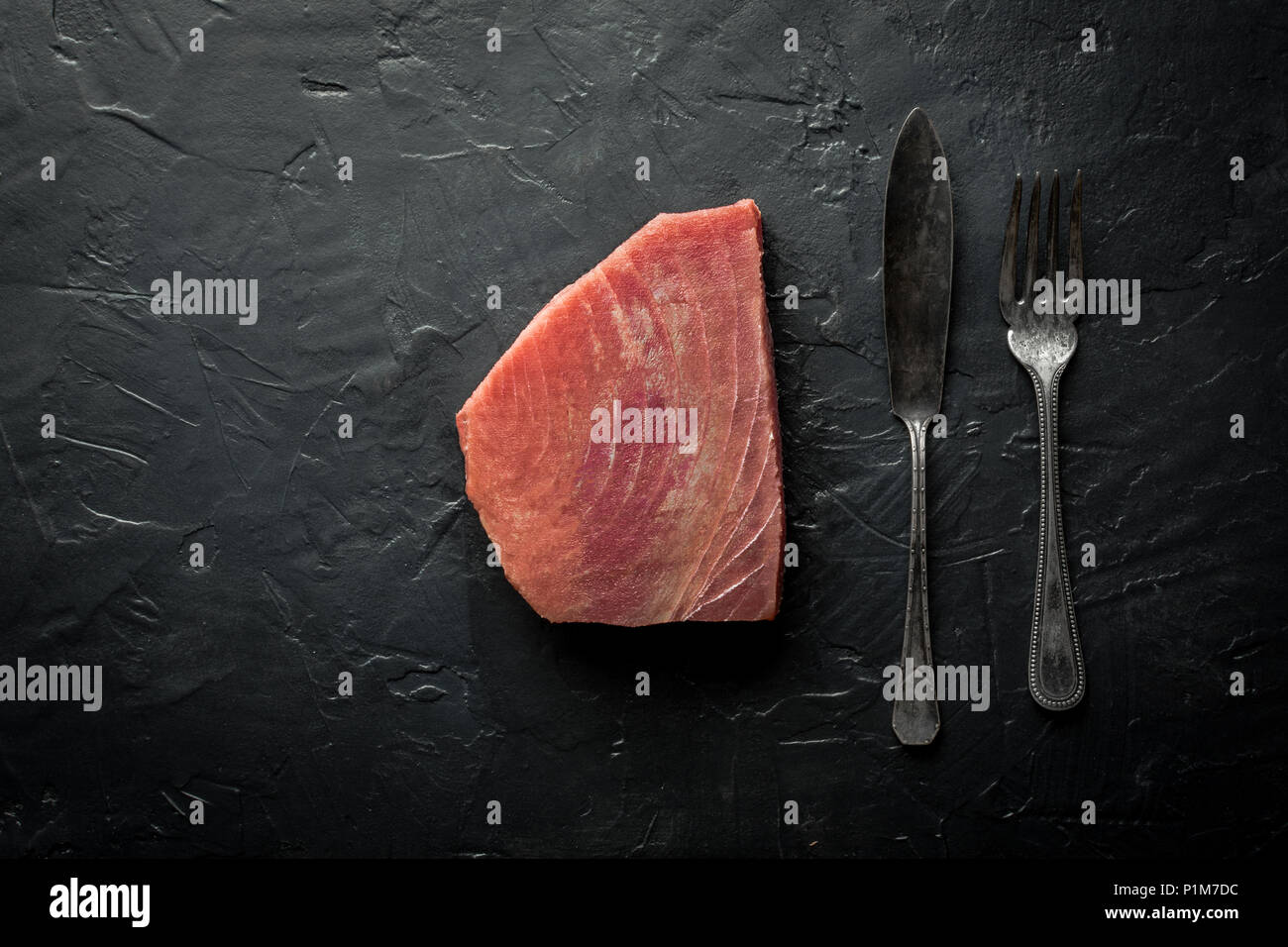 Raw Tuna Steak on Dark Stone Background Stock Photo