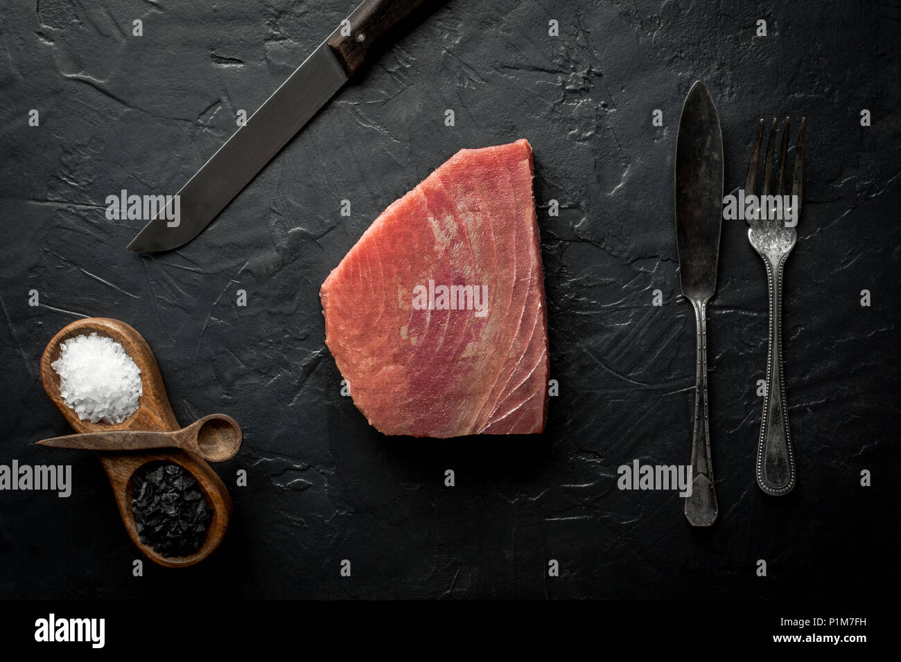 Raw Tuna Steak on Dark Stone Background Stock Photo