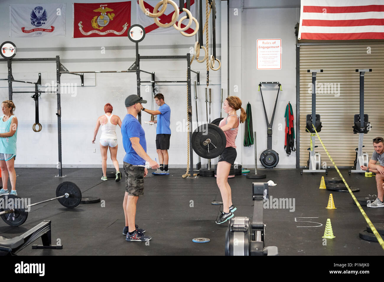 Female or woman competing in a CrossFit fitness challenge competition by dead lifting weights inside a gym in Montgomery Alabama, USA. Stock Photo