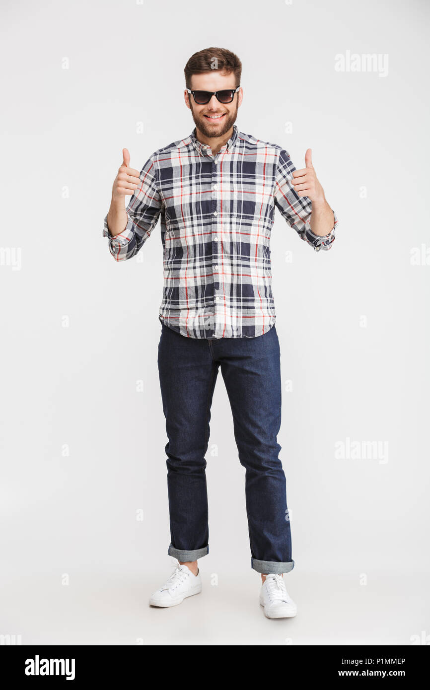 Full length portrait of a confident young man in plaid shirt and ...