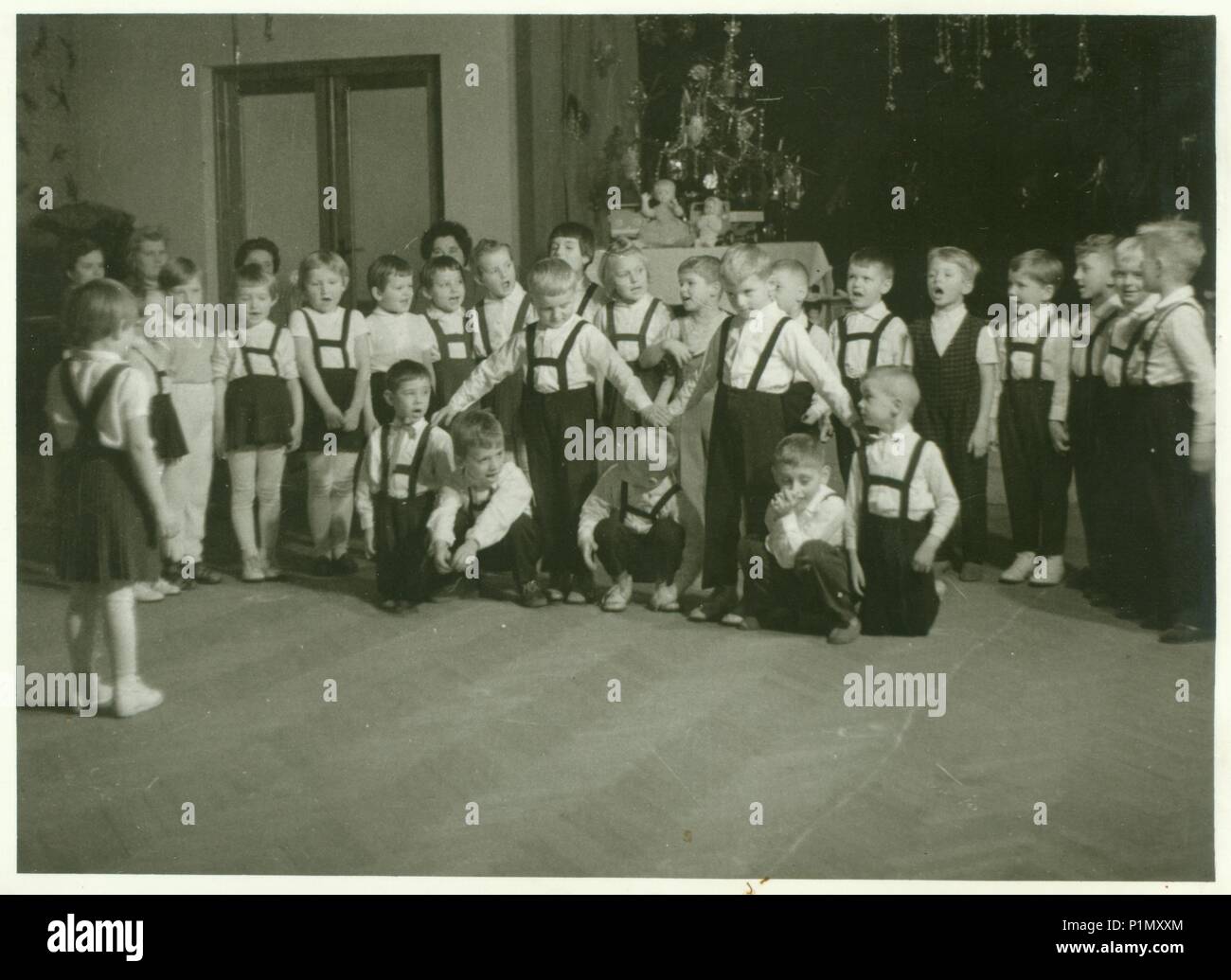 THE CZECHOSLOVAK SOCIALIST REPUBLIC - CIRCA 1960s: Retro photo shows small pupils in the classroom. Schoolmates participate in school performance during Christmas time.  Vintage black & white photography. Stock Photo