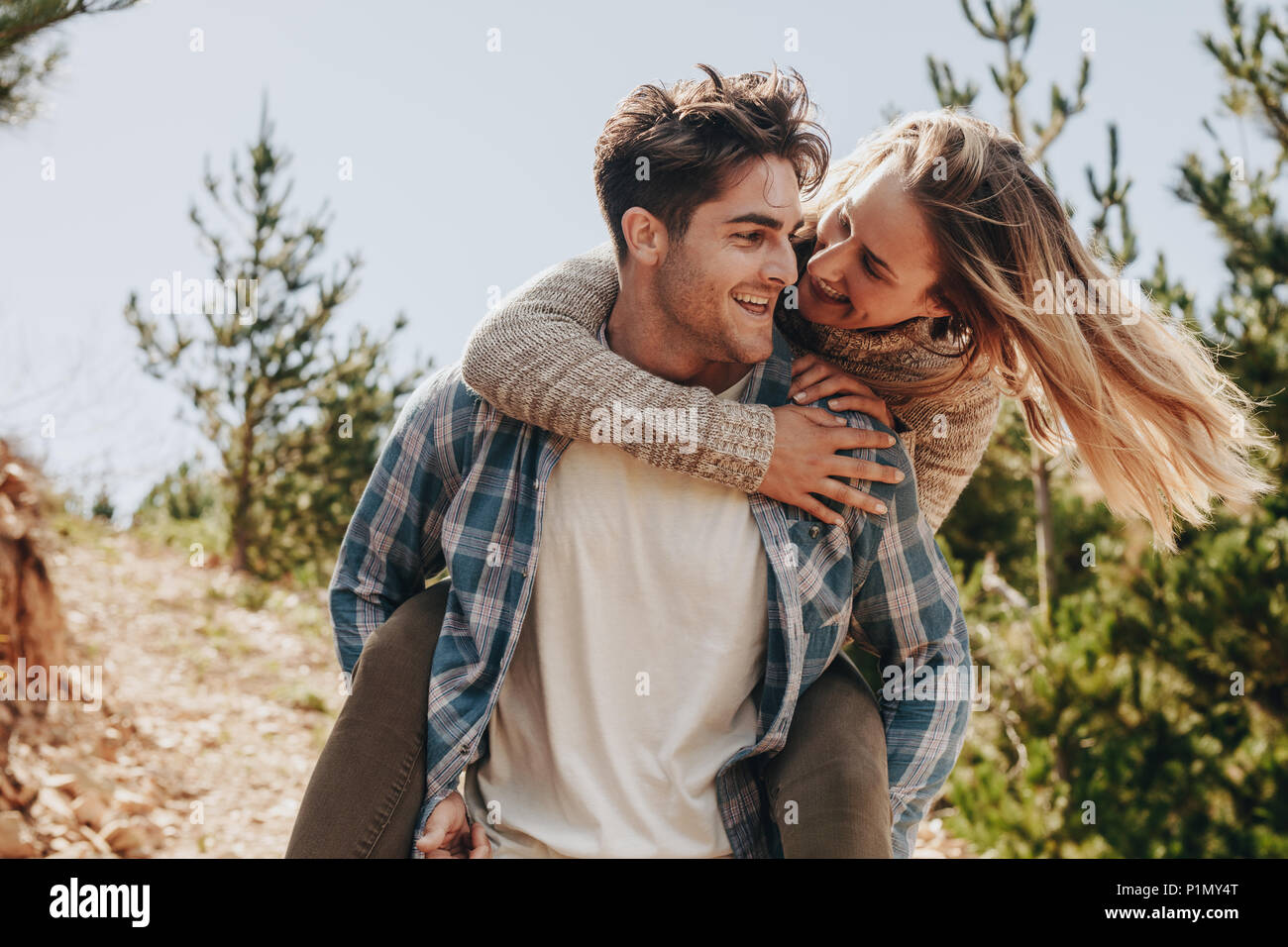 Young Man Giving Woman Piggyback Outdoors, Stock image