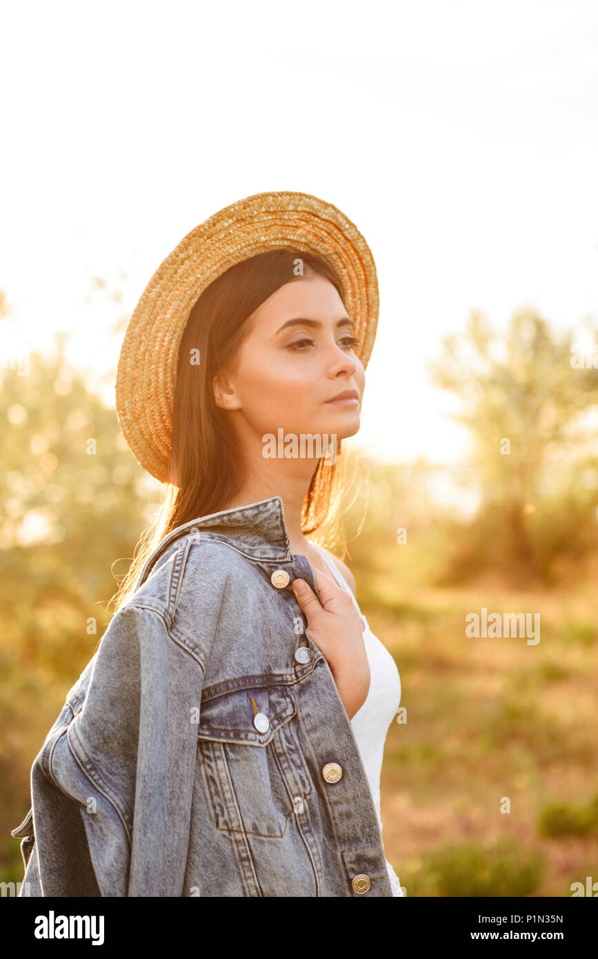 Photo of elegant european woman with long dark hair wearing straw hat