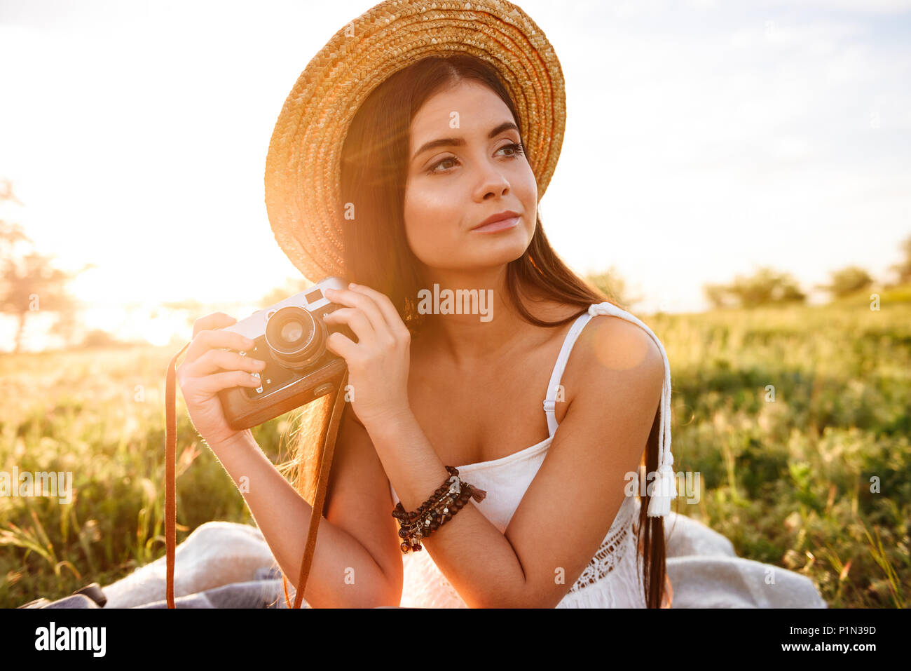 long dark hair wearing straw hat 