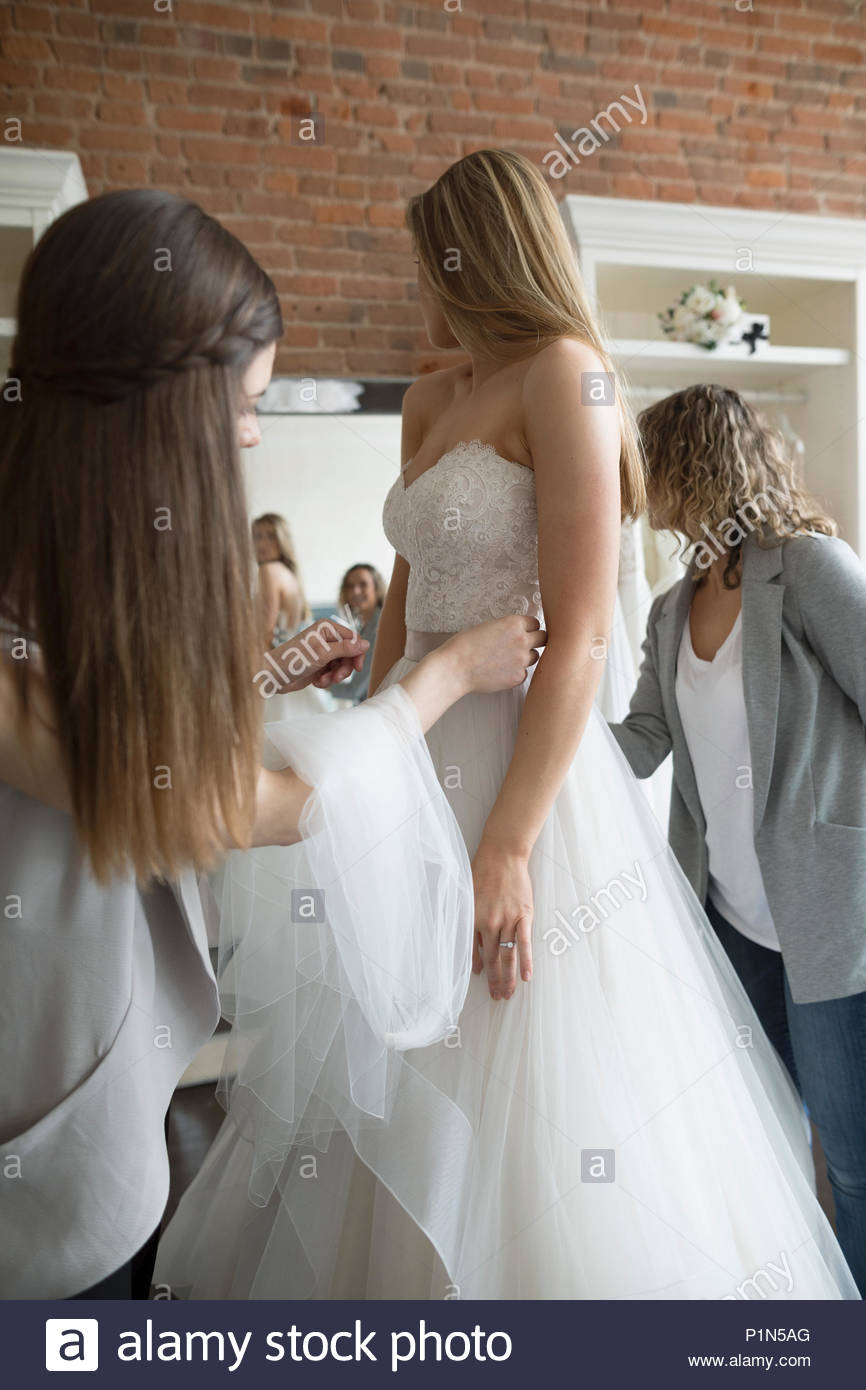 Bride and friends at wedding dress fitting in bridal boutique Stock Photo