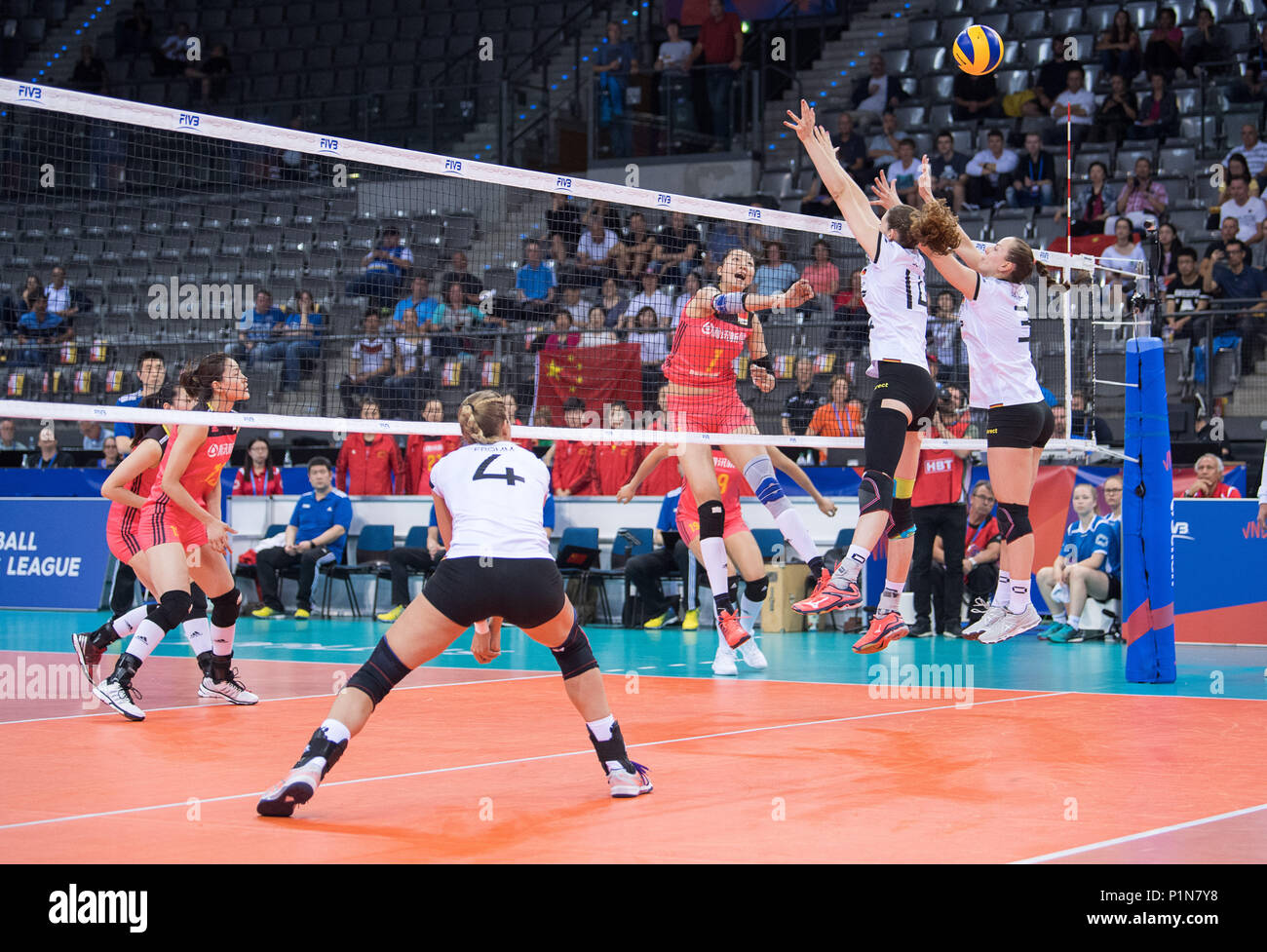 12 June 2018, Germany, Stuttgart: Volleyball, women's Nations League match between Germany and China at the Porsche Arena: China's Xinyue Yuan (3.f.r) smashes the ball. Germany's Marie Schoelzel (2.f.r) and Denise Hanke (r) jump to block. Photo: Sebastian Gollnow/dpa Stock Photo
