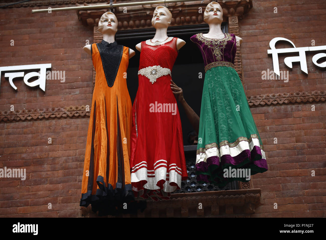 June 13, 2018 Kathmandu, Nepal A shopkeeper arranges mannequins