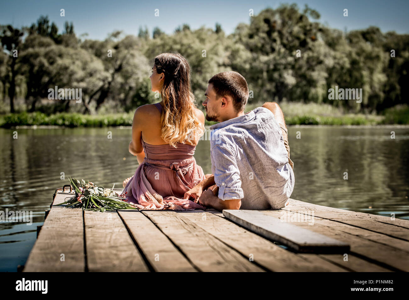 beautiful love young couple on the pier near the river Stock Photo - Alamy