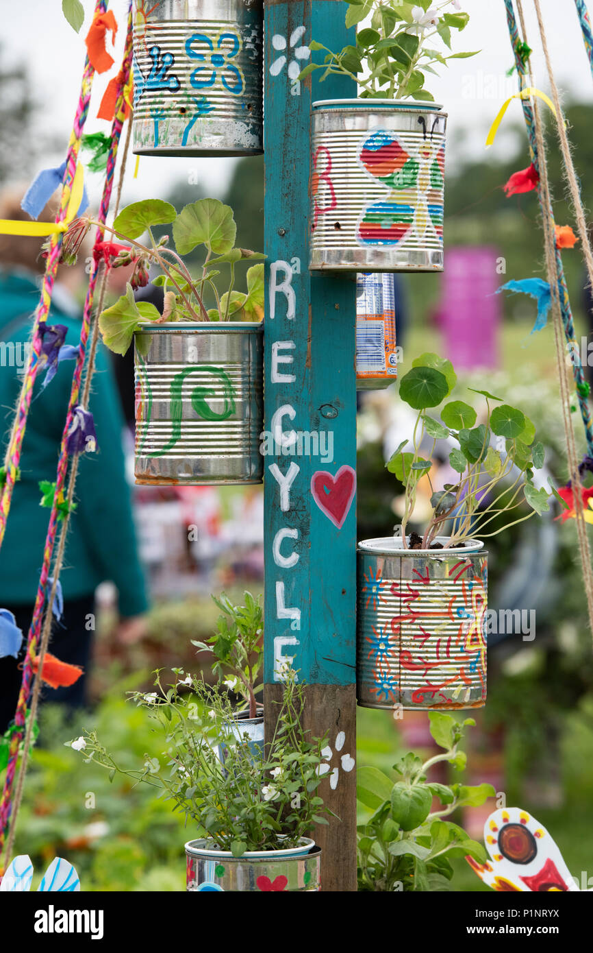 Painted Childerns recycled tin flower pots display at a flower show. UK Stock Photo