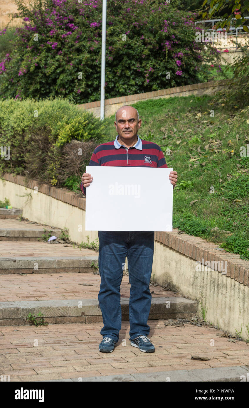 Man holding blank sign in the medieval city of Iglesias, Italy Stock Photo