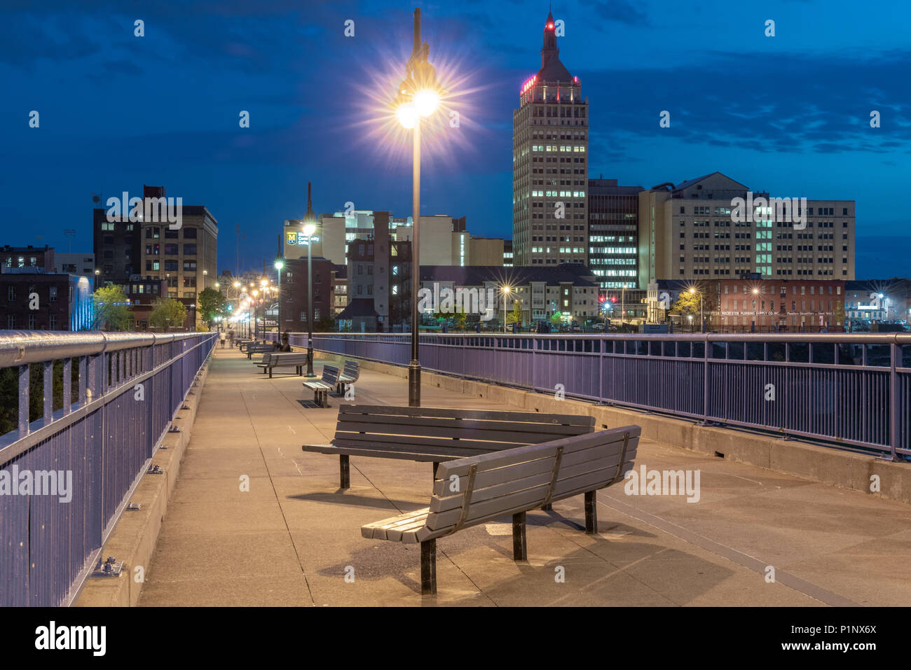 ROCHESTER, NY - MAY 14, 2018: Skyline of Rochester, New York along the Pont De Rennes Pedestrian Bridge which is part of the Genesee Riverway Trail at Stock Photo