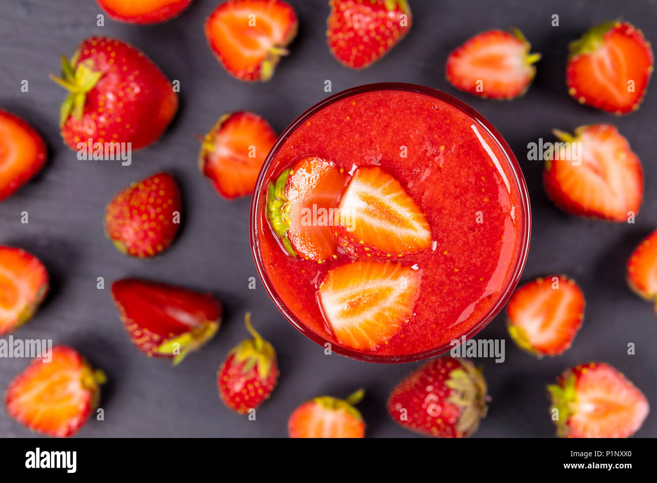 Strawberry in fresh smoothie on black table. Healthy drinking concept. Stock Photo