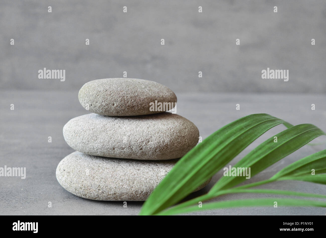 Stones balance and green palm leaf. Zen and spa concept. Stock Photo