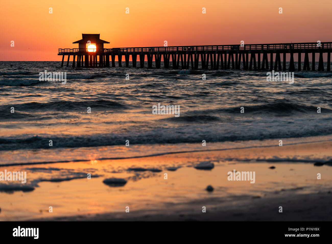 Naples, Florida red tide and orange sunset in gulf of Mexico with sun