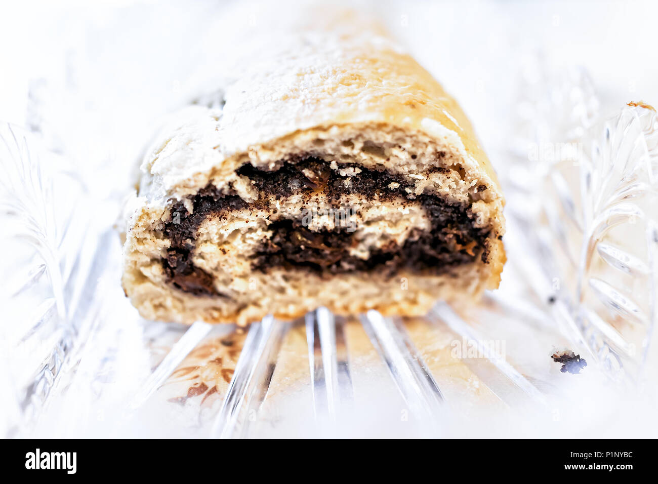 Closeup cut cross section of golden baked whole poppy seed roll cake