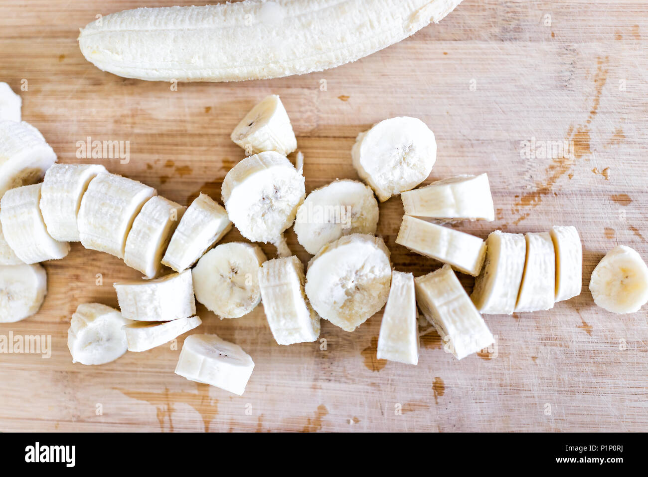 Chopped frozen banana flat top view down on wooden bamboo chopping ...