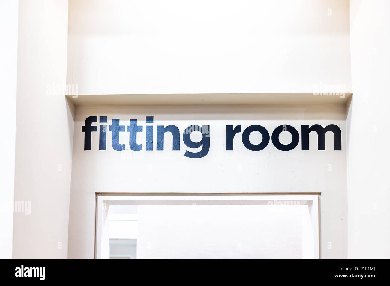 Closeup of Fitting Room sign in mall store shop retail clothing changing door entrance with nobody on wall Stock Photo