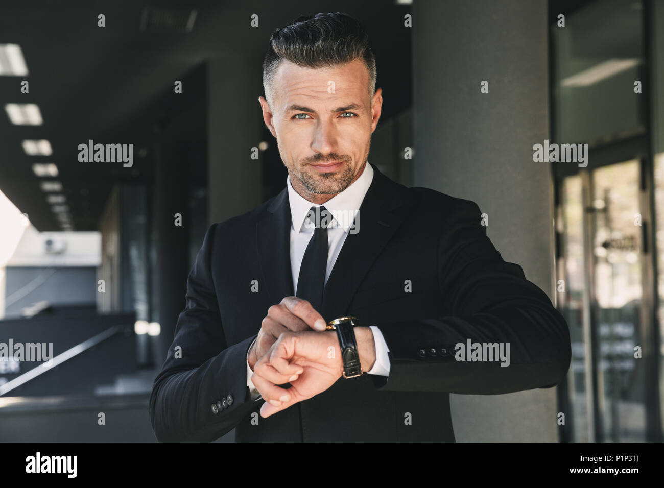 Portrait of a confident young businessman dressed in suit standing ...