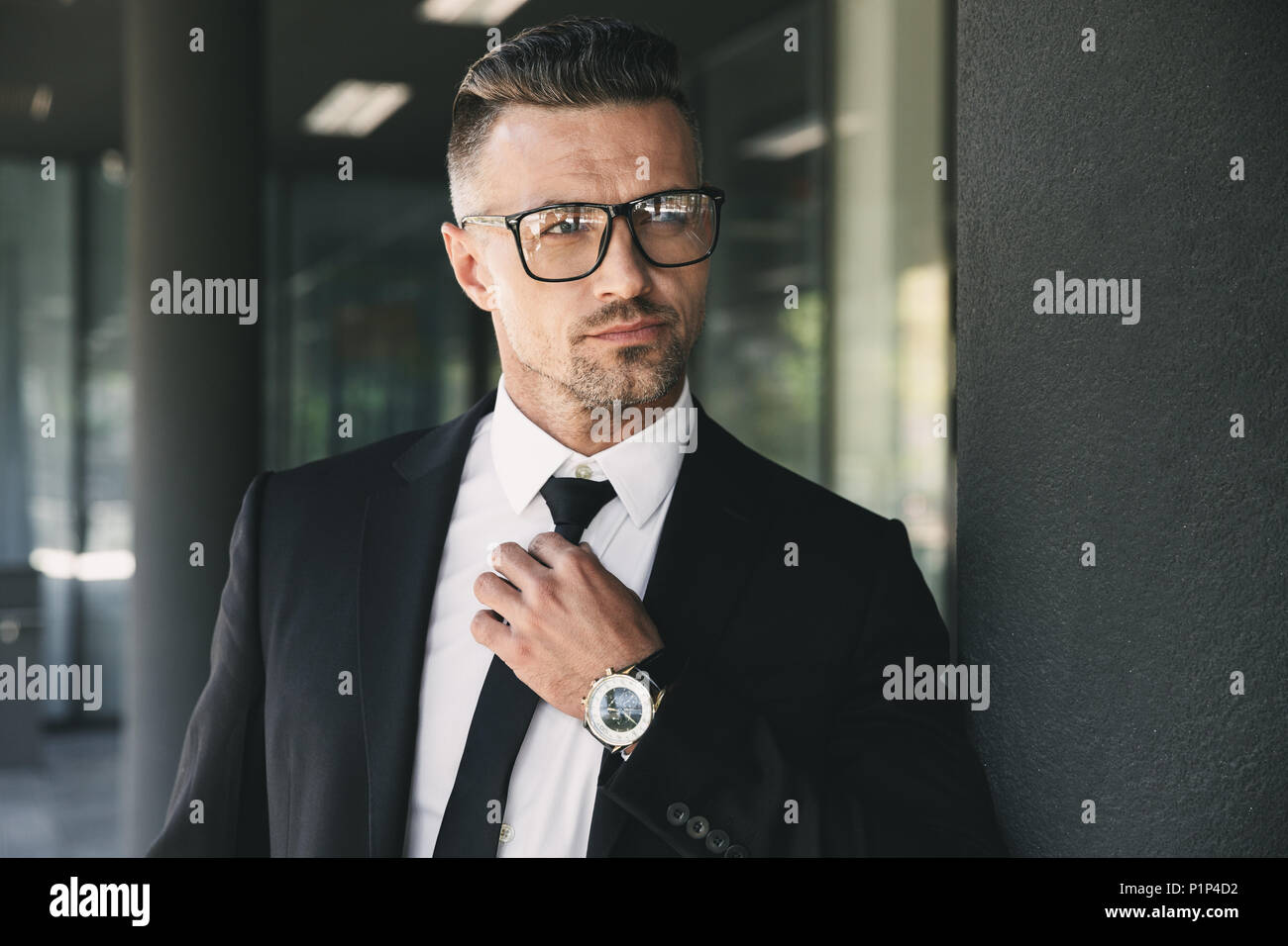 Portrait of a confident young businessman dressed in suit standing ...