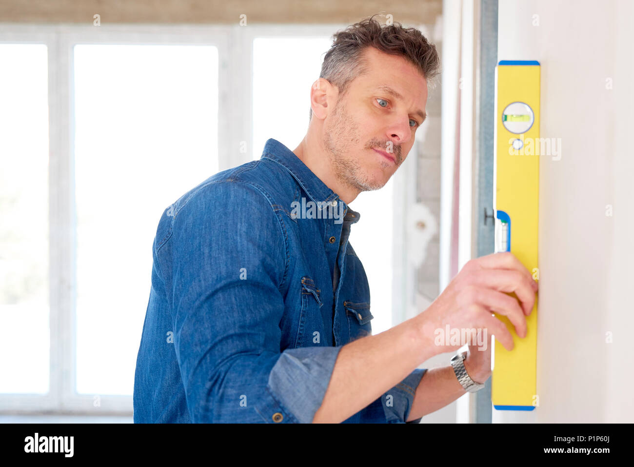 Handyman Using Spirit Level While Working On Construction Site Stock Photo Alamy