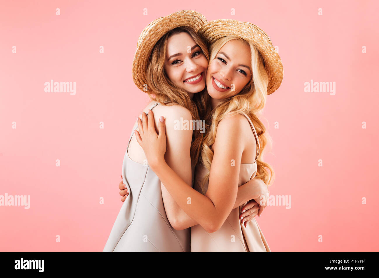 Portrait of two pretty young women in summer clothes hugging and ...