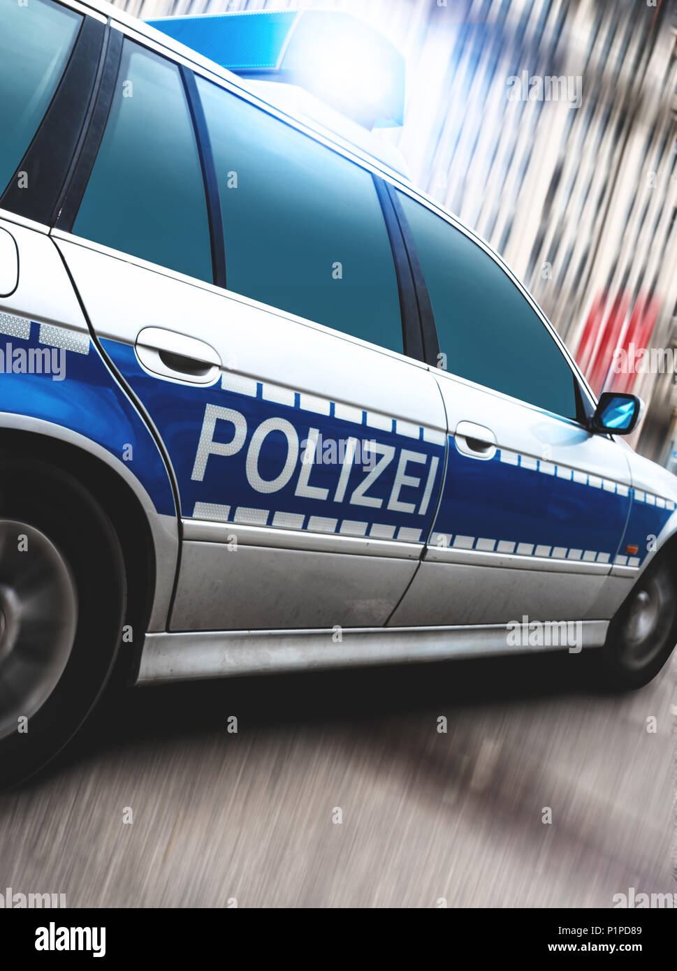 close-up of police car with flashing emergency lights on motion blurred urban street Stock Photo