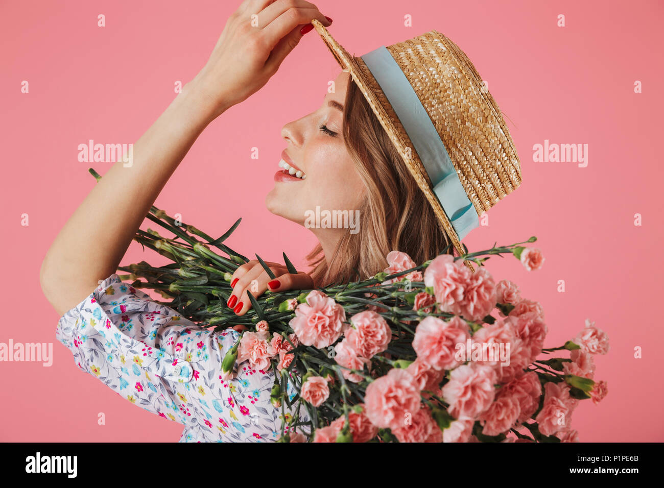 Close up portrait of a happy young woman in summer dress and straw hat ...