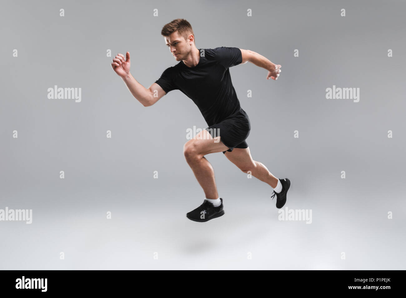 Running Portrait Full length portrait of a concentrated young sportsman running fast ...