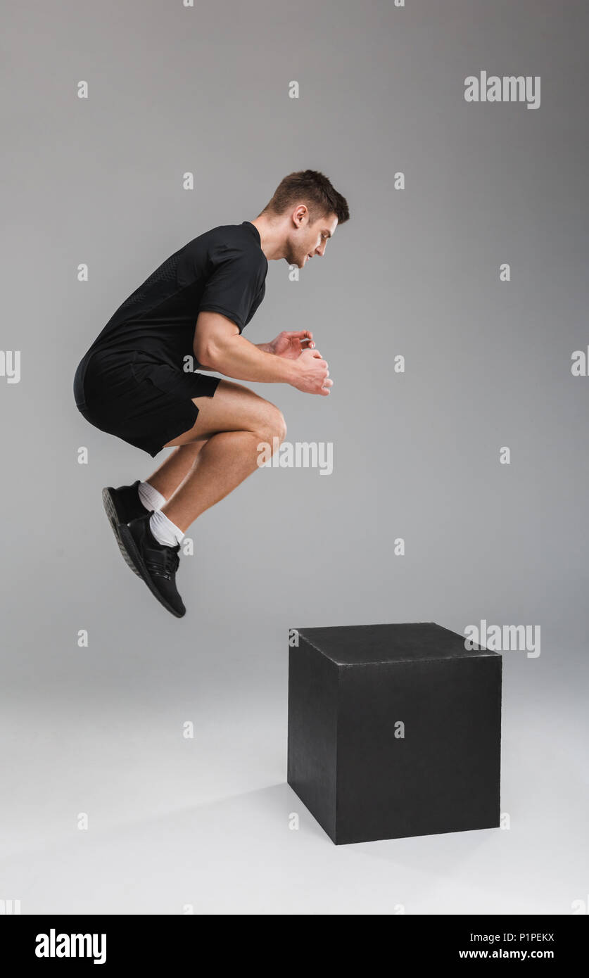 Full length portrait of a concentrated young sportsman jumping on a