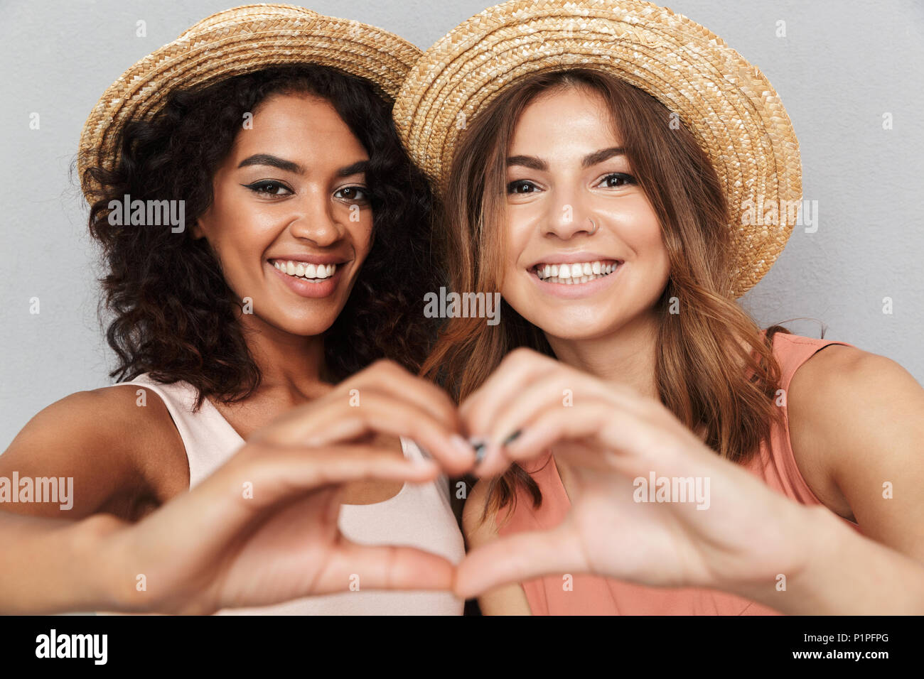 Close up portrait of two smiling young women dressed in summer clothes ...