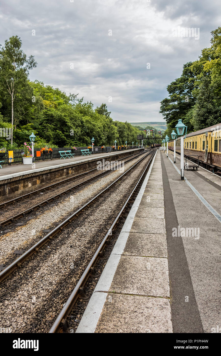 Diminishing perspective of the tracks and lamps at Goathland station; Yorkshire, England Stock Photo