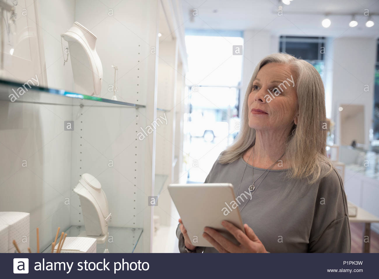 Senior jewelry boutique business owner with digital tablet Stock Photo