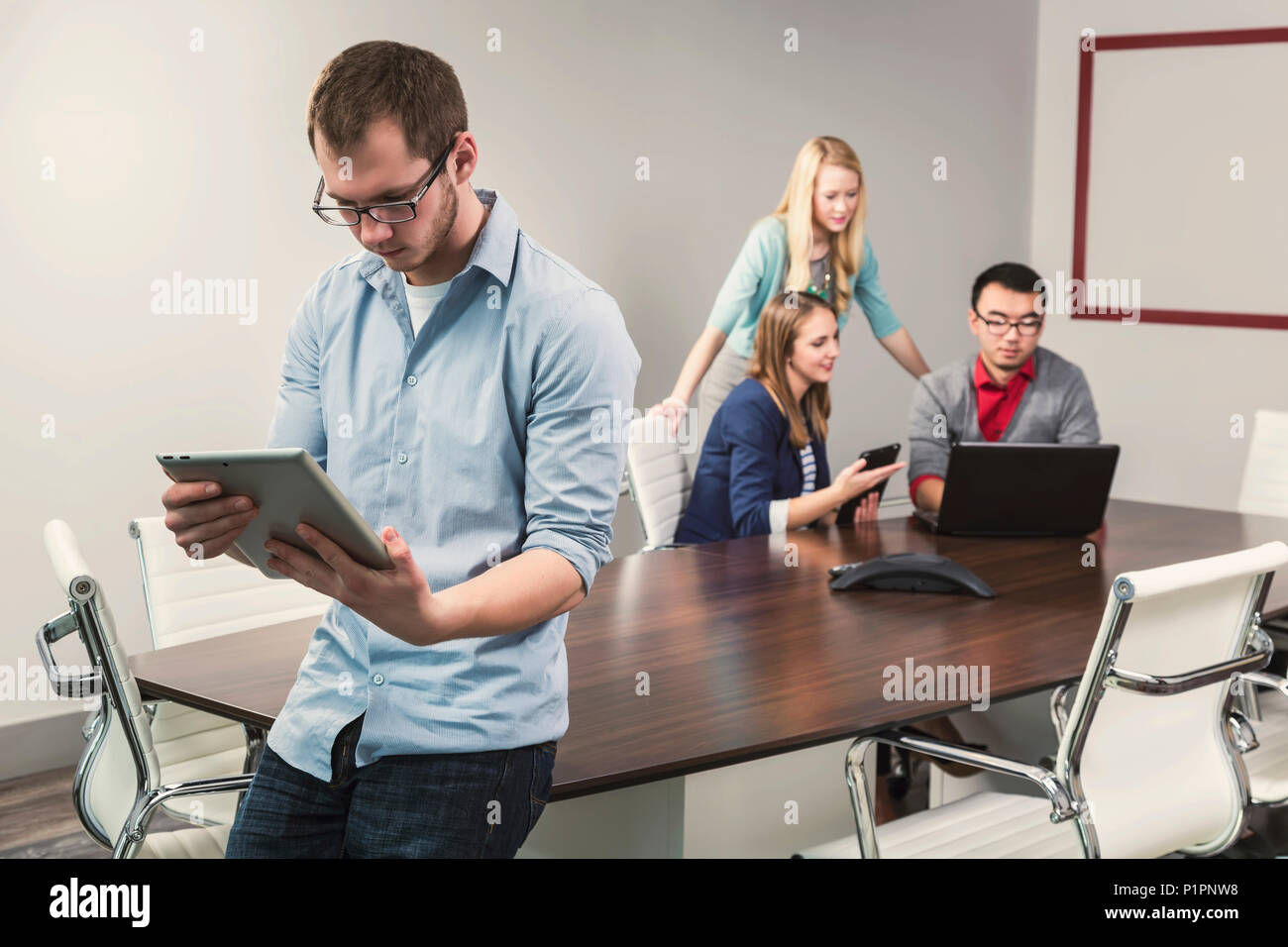 Young millennial business professionals working together in a conference room in a high tech modern business; Sherwood Park, Alberta, Canada Stock Photo