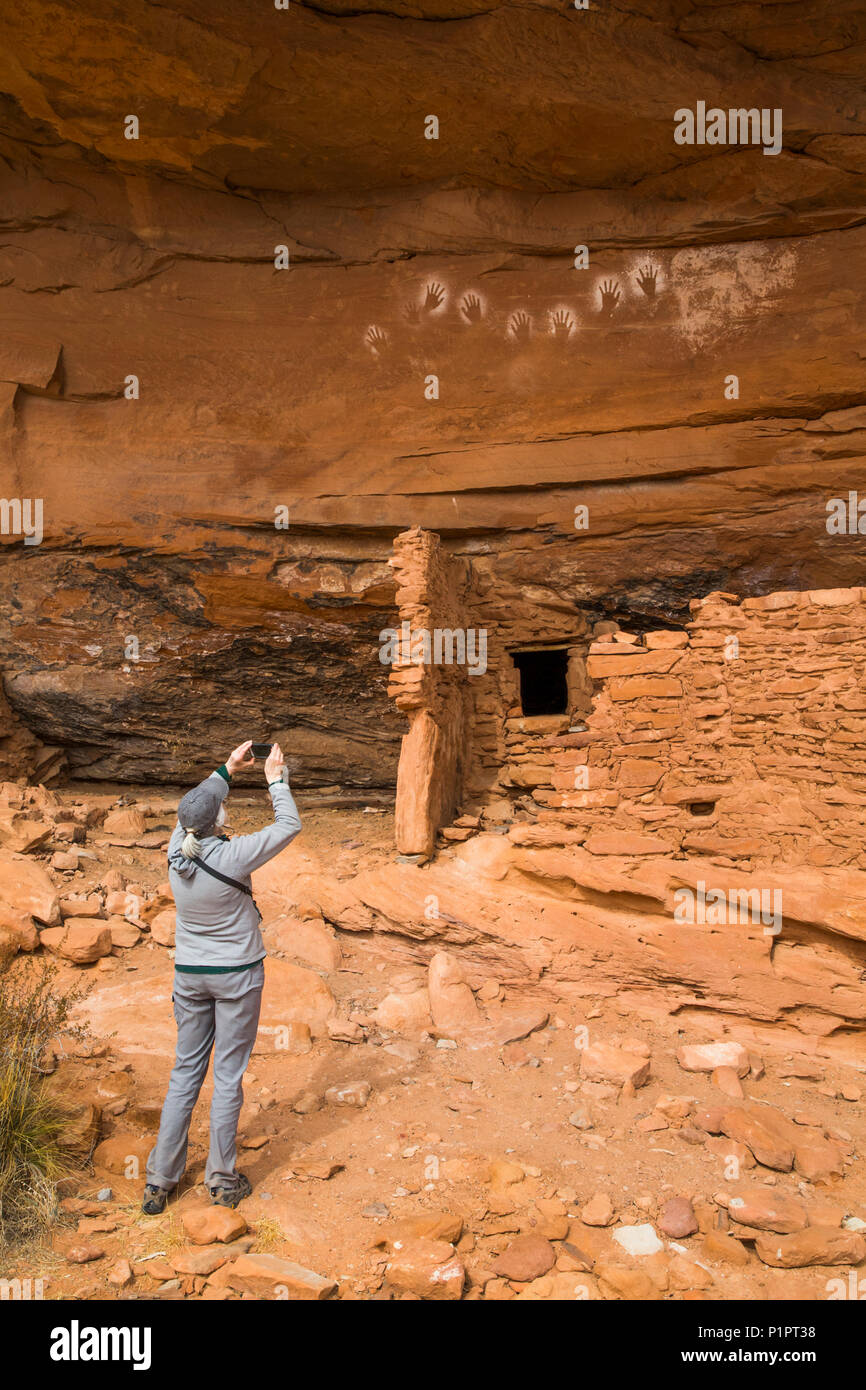 Hiker taking a photograph, Ancestral Pueblo, up to 1,000 years old, Bears Ears National Monument; Utah, United States of America Stock Photo
