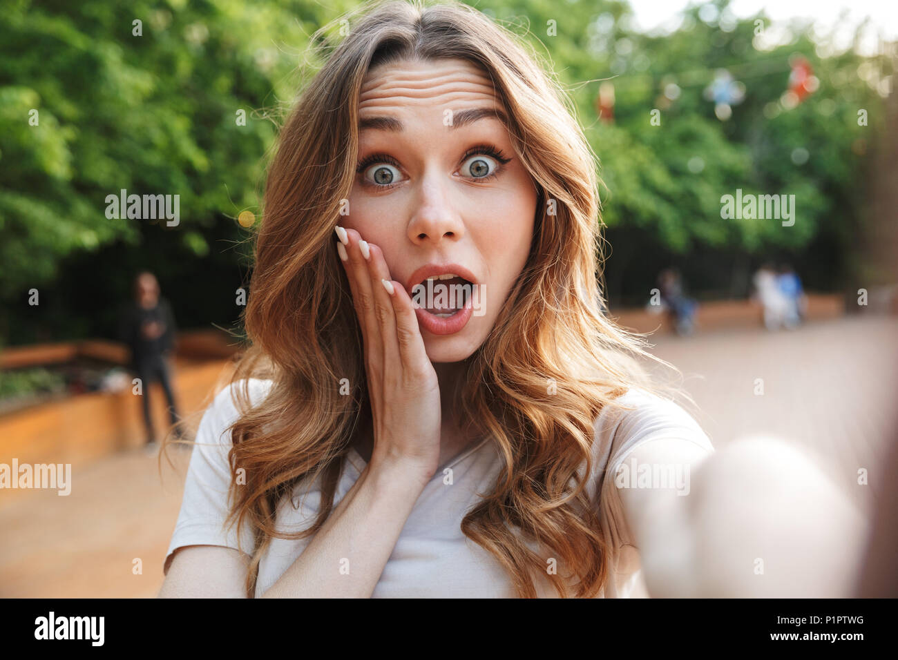 Close up of an amazed young girl taking selfie with outstretched hand ...