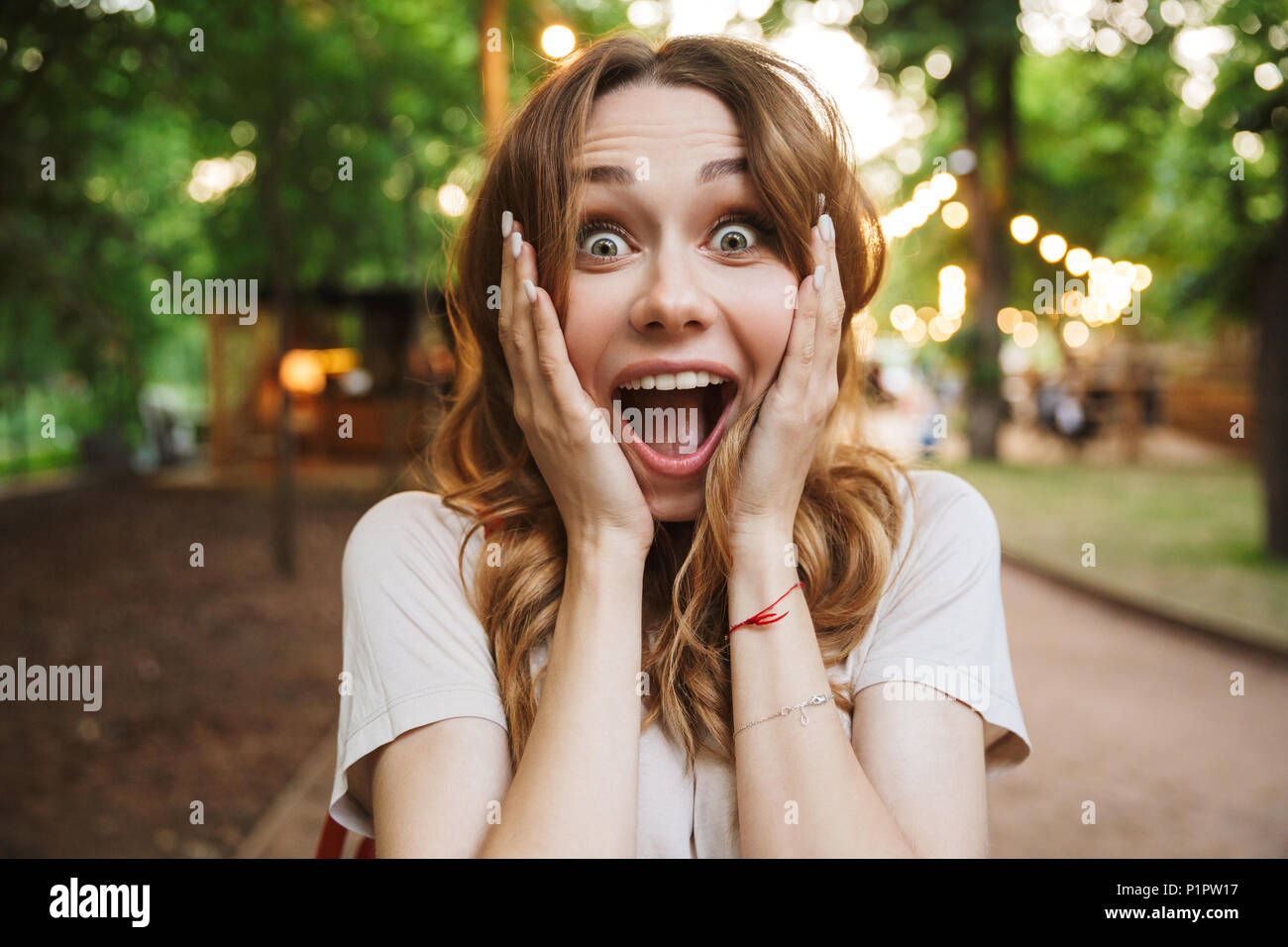 Close up of happy young girl screaming while standing at the park Stock Photo