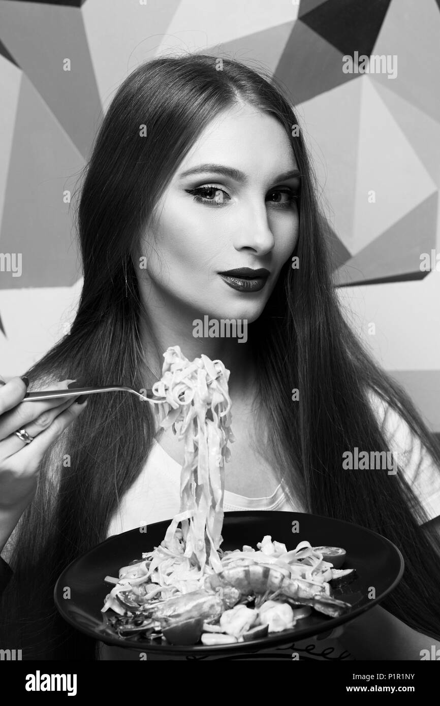 Portrait of attractive long haired woman with slightly ajar mouth and red lips eating Italian