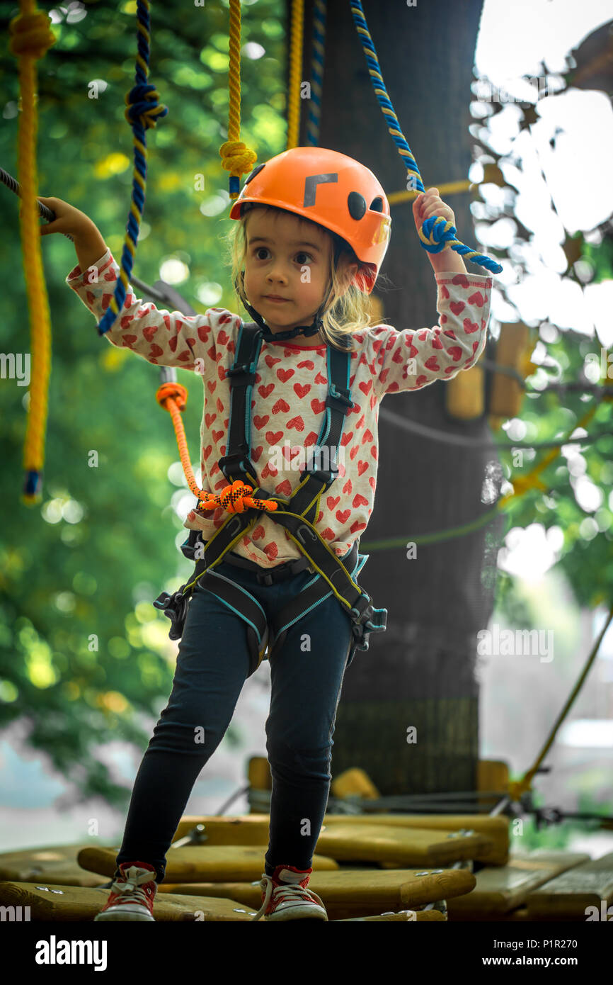 sports happy kid climbs through the ropes, the beautiful girl in the