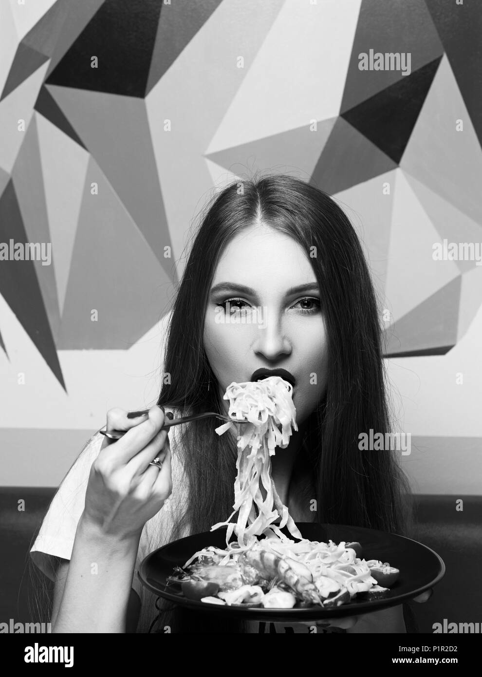 Portrait of attractive long haired woman with slightly ajar mouth and red lips eating Italian