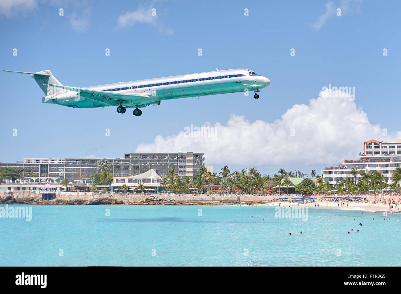 Plane landing in paradise island on sunny day with blue water Stock Photo