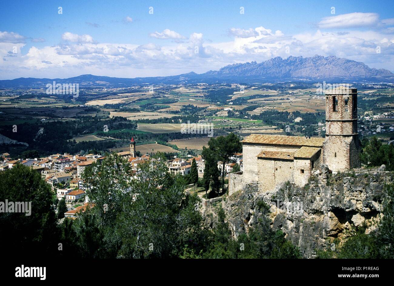 Gélida, town and sant Pere romanesque church with Monserrat at the background. Stock Photo