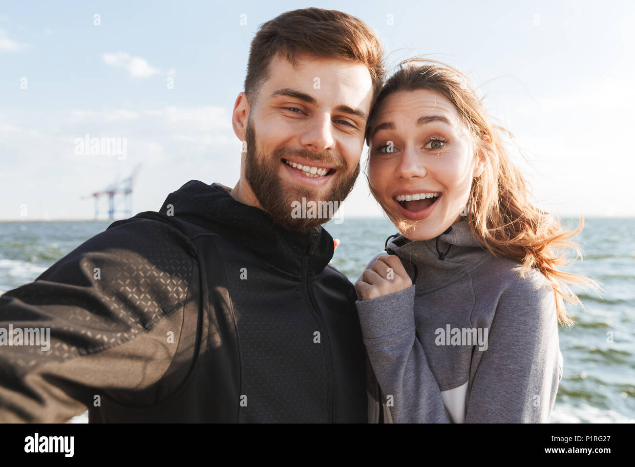Happy young sports couple taking a selfie while standing together at ...