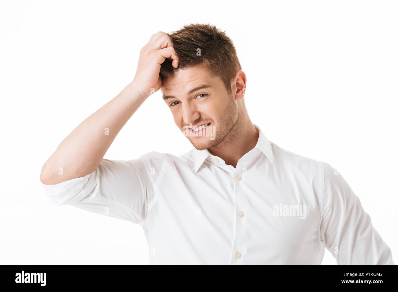 Portrait of a confused young man scratching his head isolated over white background Stock Photo