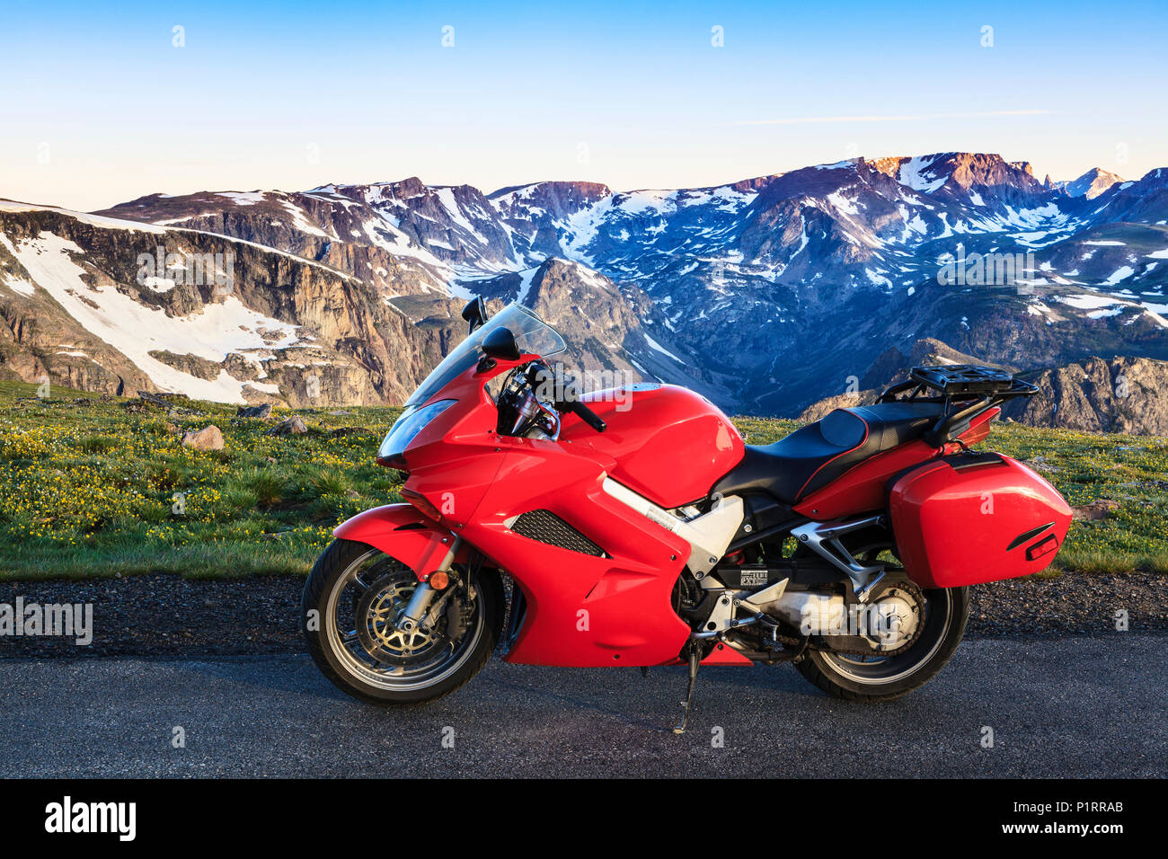 View from the Beartooth Highway of the Beartooth Mountains and a motorcycle parked on the roadside; Cody, Wyoming, United States of America Stock Photo