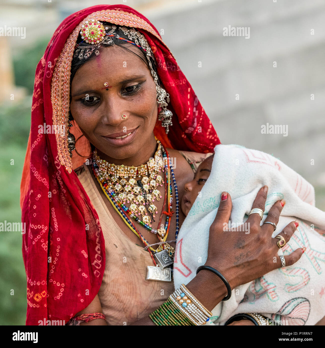 A mother holding her sleepy baby; Jaisalmer, Rajasthan, India Stock Photo
