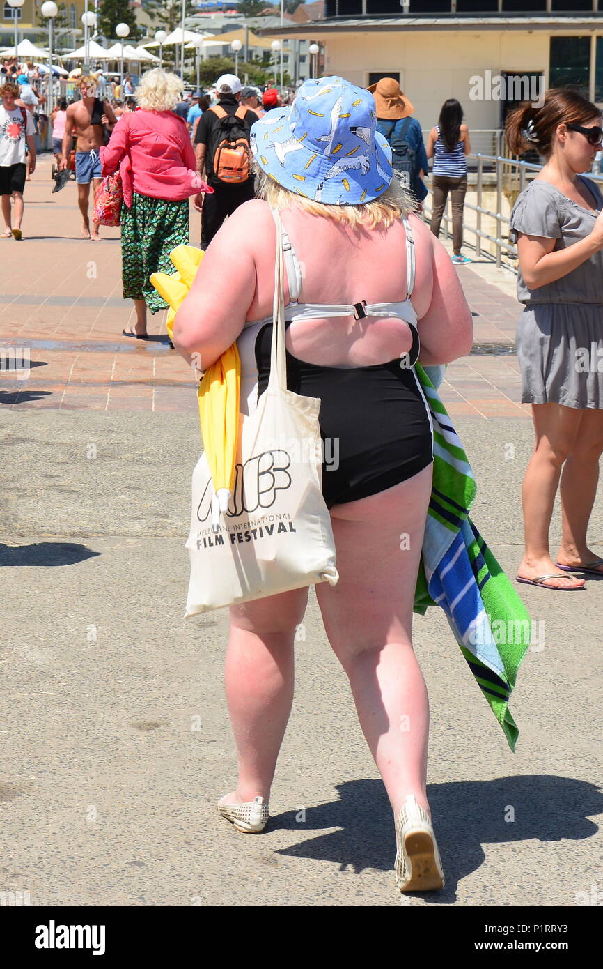 Back of an overweight, obese woman wearing swimsuit on beach Stock Photo
