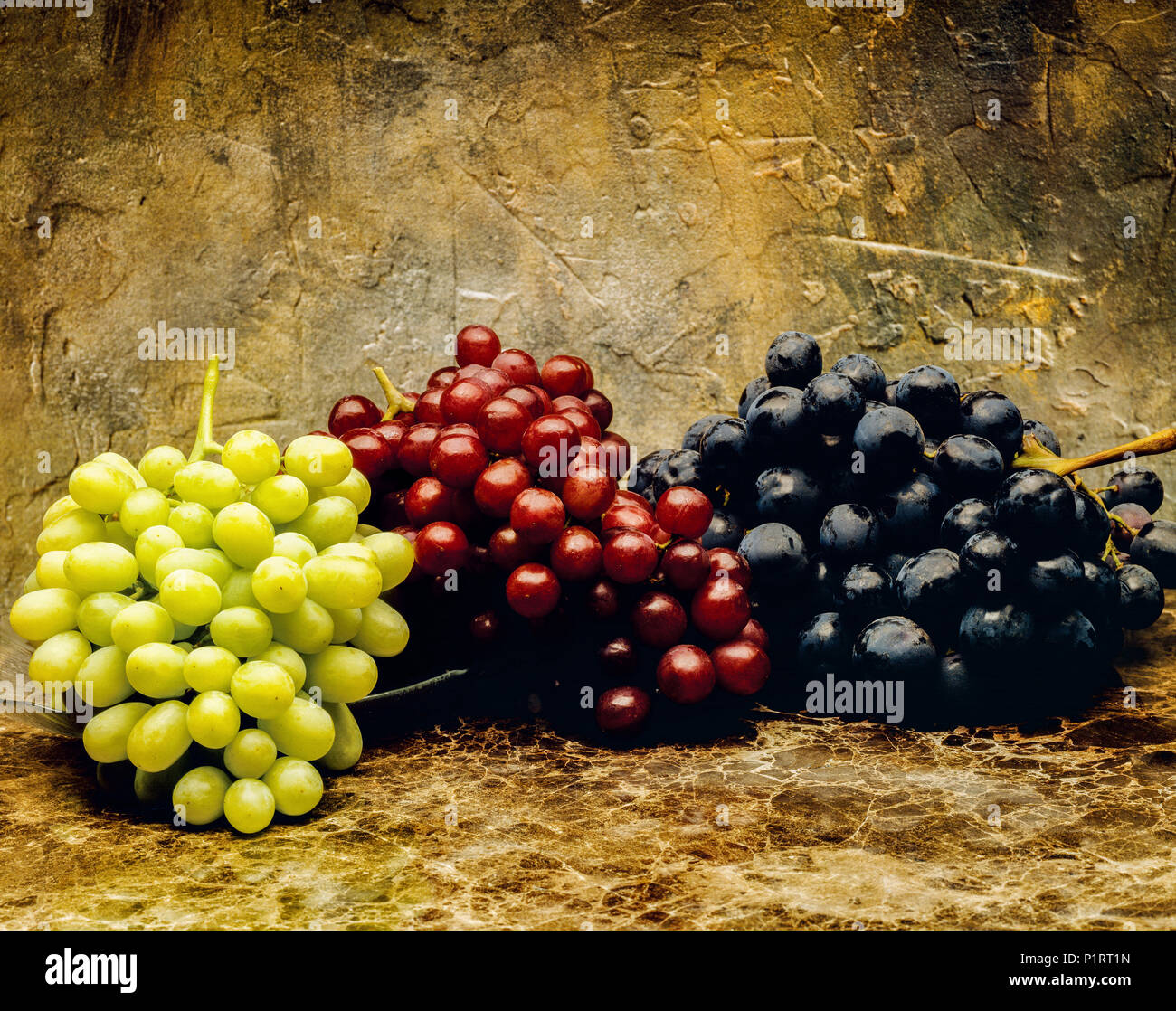 Agriculture - Green, red and black table grapes on marble, studio. #2. Stock Photo