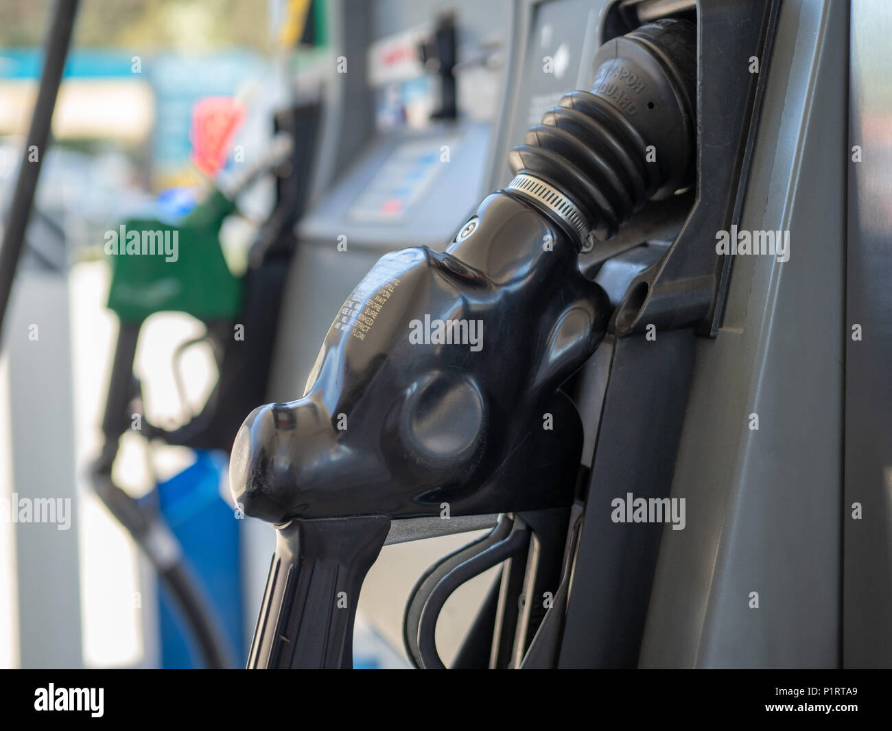 A gas station fuel nozzle sitting in holster waiting to be used Stock Photo